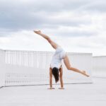a woman is doing a handstand on the ground