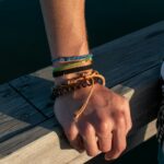a person with a bracelet on their hand on a dock